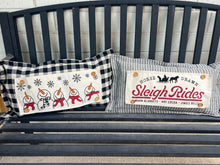 Load image into Gallery viewer, Two decorative pillows on a bench with festive designs and text.