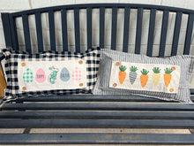Load image into Gallery viewer, Two decorative pillows with Easter-themed designs on a wooden bench.