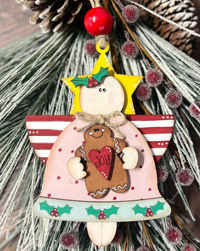 Angel Christmas ornament with a gingerbread man and 'Joy' text on a tree.