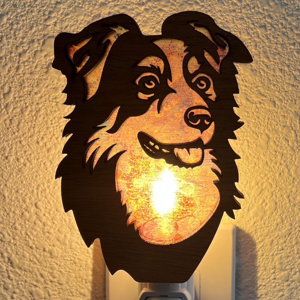 A laser-cut wooden night light in the shape of a dog's head, glowing with a warm light.