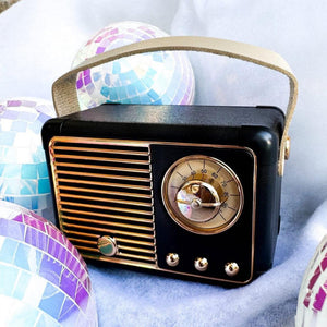 Vintage-style black radio with gold accents on a light blue background