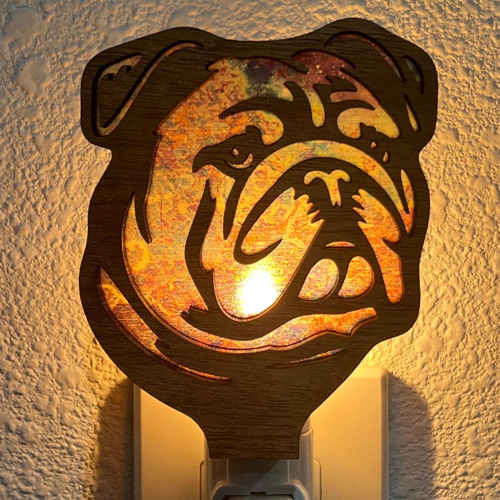 A laser-cut wooden night light in the shape of a dog's head, glowing with a warm light.