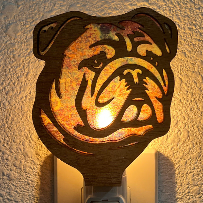 A laser-cut wooden night light in the shape of a dog's head, glowing with a warm light.