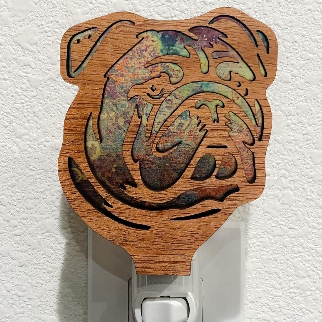 A laser-cut wooden night light in the shape of a dog's head, shown against a white wall