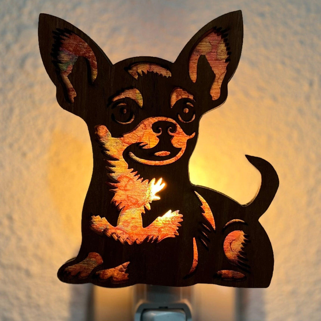 A laser-cut wooden night light in the shape of a dog's head, glowing with a warm light.
