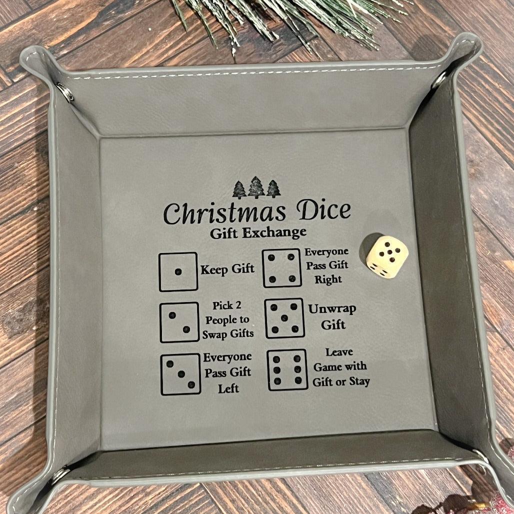 Gray leather dice tray with engraved Christmas Dice Gift Exchange rules and a single die inside.