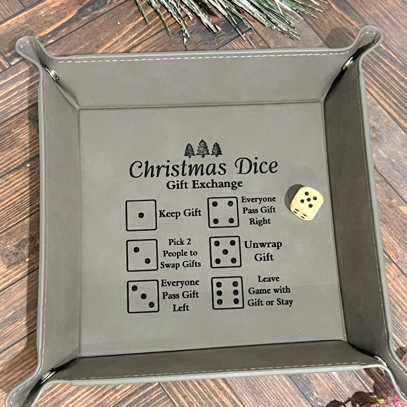 Gray leather dice tray with engraved Christmas Dice Gift Exchange rules and a single die inside.