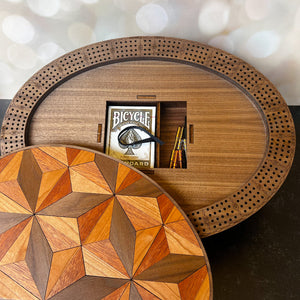 Wooden circular table with geometric pattern and Bicycle card box on a blurred background