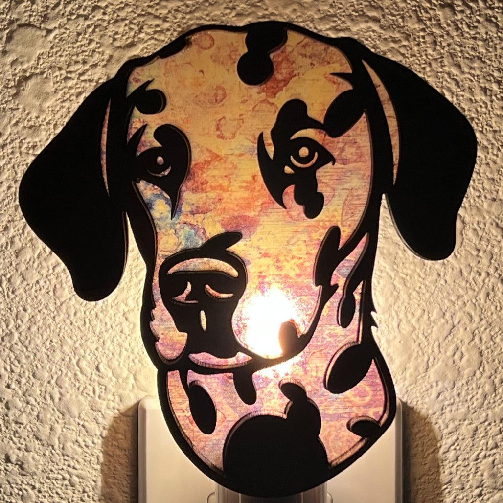 A laser-cut wooden night light in the shape of a dog's head, glowing with a warm light.