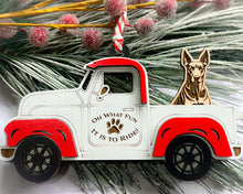 Load image into Gallery viewer, A vintage style red and white truck ornament with a dog riding in the back seat, placed on a branch with Christmas decorations.