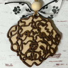 Load image into Gallery viewer, Laser-cut wooden doodle art dog ornament with paw print ribbon bow and bead, hanging on rustic twine.