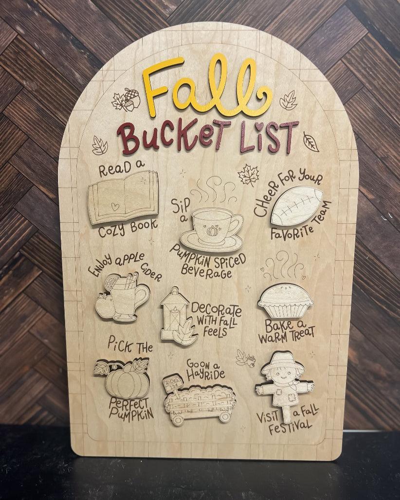 Wooden plaque with 'Fall Bucket List' activities on a wooden background