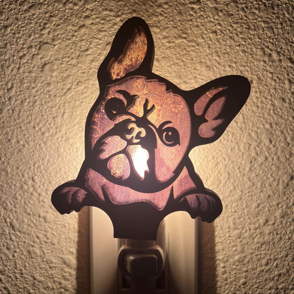 A laser-cut wooden night light in the shape of a dog's head, glowing with a warm light.