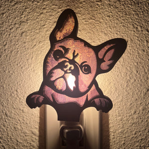 A laser-cut wooden night light in the shape of a dog's head, glowing with a warm light.