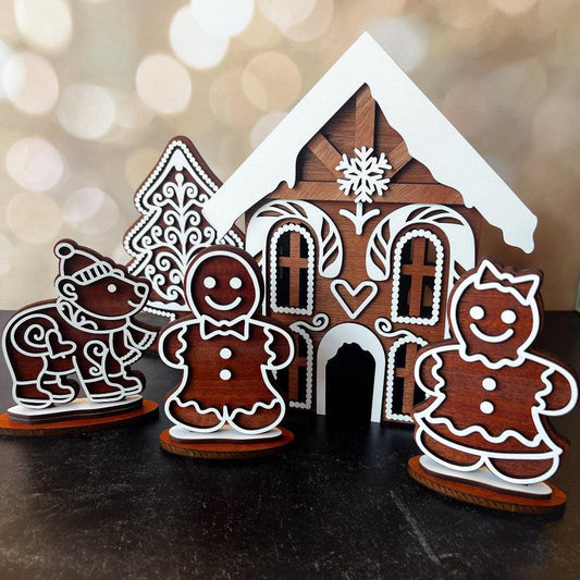 Wooden gingerbread house and figures on a dark surface with a blurred light background