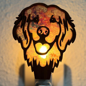 A laser-cut wooden night light in the shape of a dog's head, glowing with a warm light.