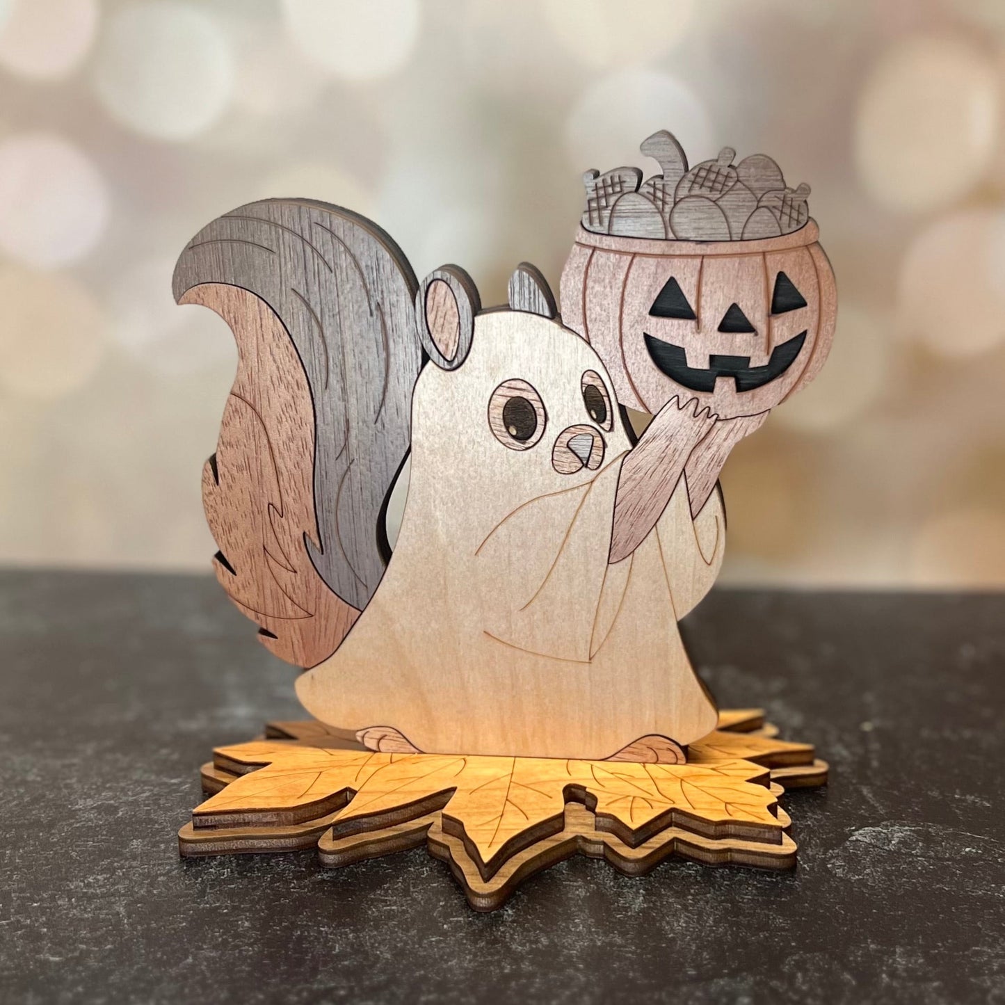 Wooden squirrel figurine holding a pumpkin lantern on a dark surface with a blurred light background