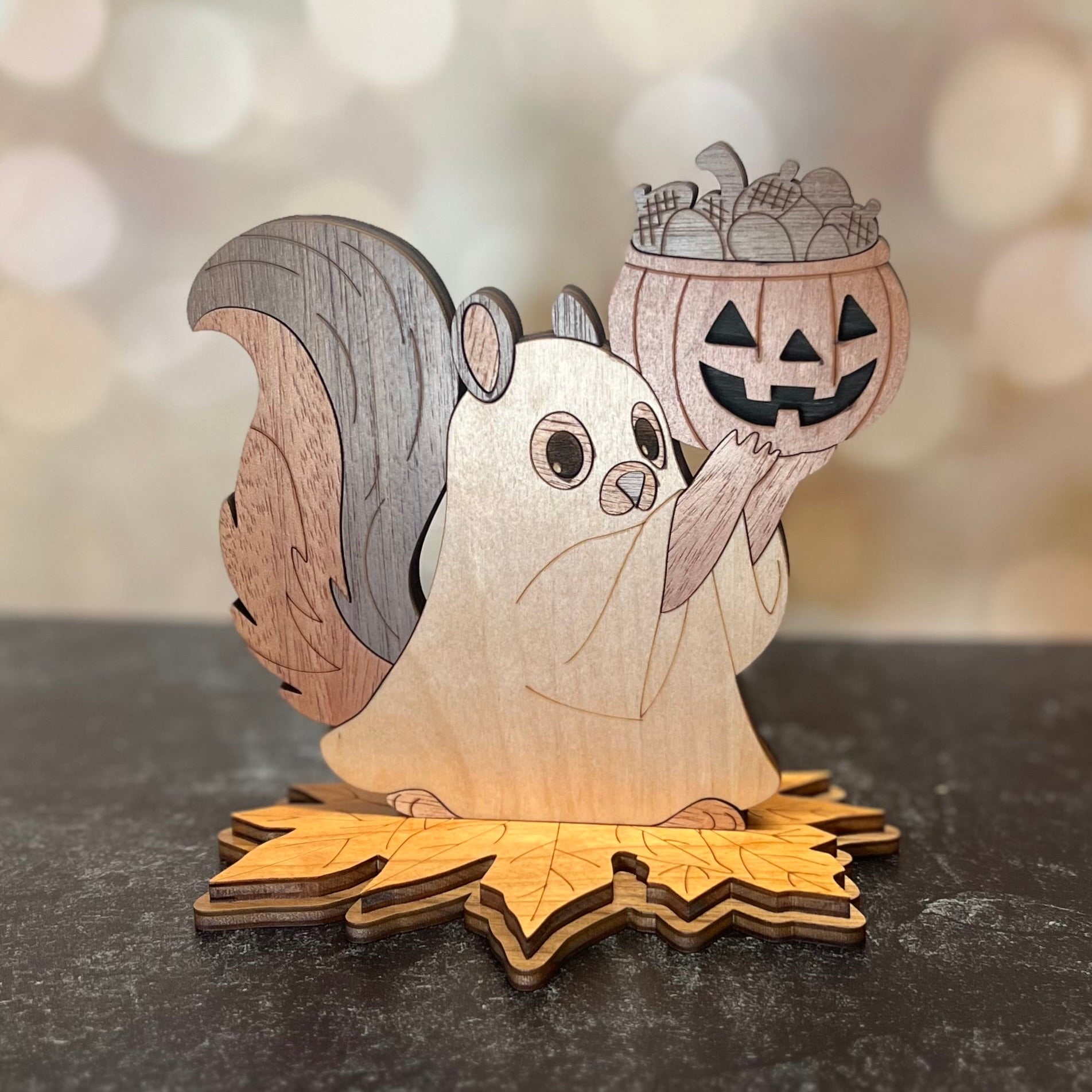 Wooden squirrel figurine holding a pumpkin lantern on a dark surface with a blurred light background