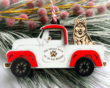 Load image into Gallery viewer, A vintage style red and white truck ornament with a dog riding in the back seat, placed on a branch with Christmas decorations.