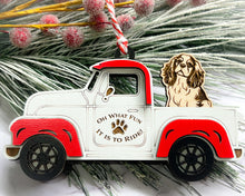 Load image into Gallery viewer, A vintage style red and white truck ornament with a dog riding in the back seat, placed on a branch with Christmas decorations.