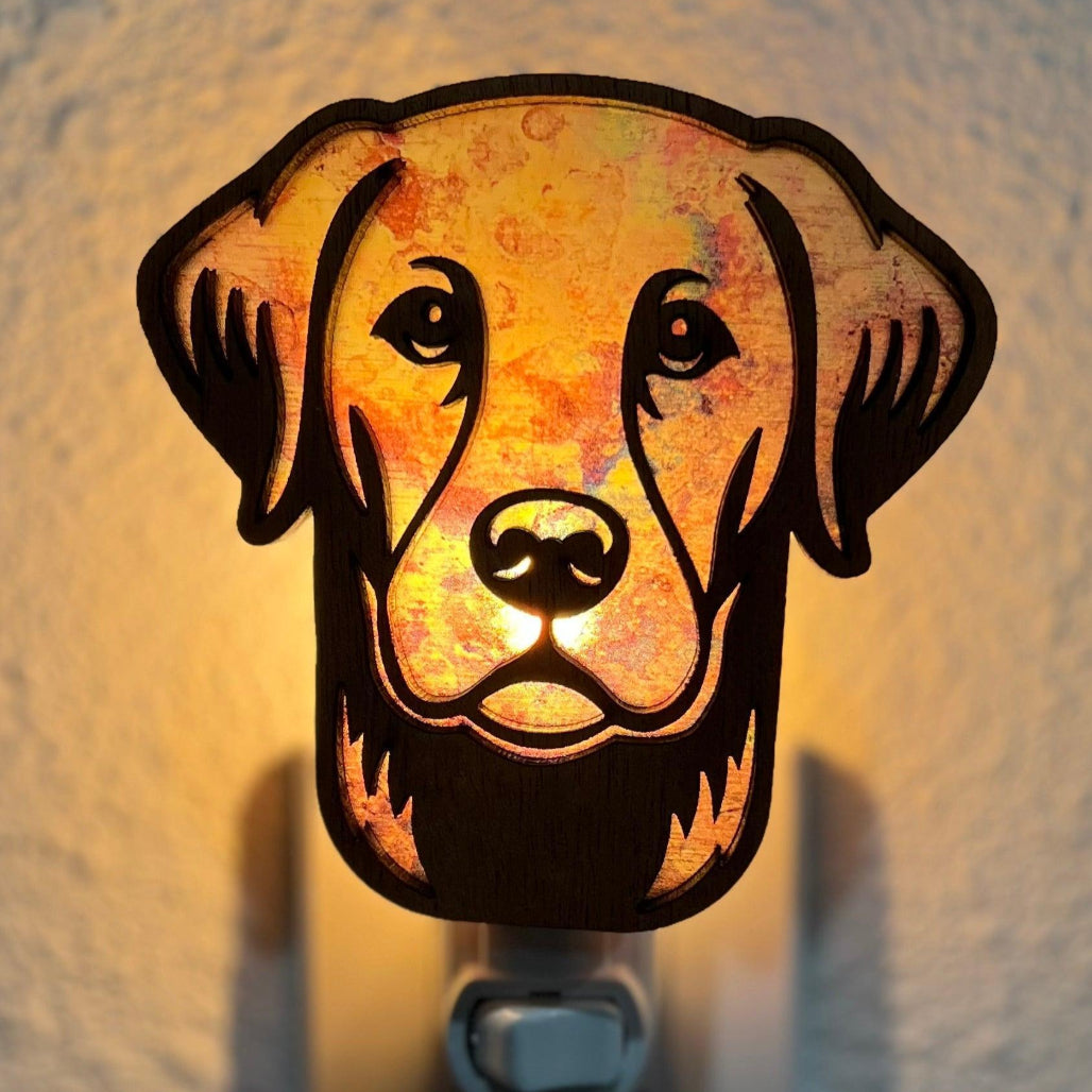 A laser-cut wooden night light in the shape of a dog's head, glowing with a warm light.