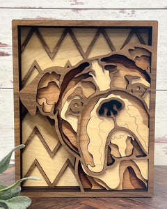 A handcrafted layered wood art piece depicting a bulldog with a geometric zigzag pattern in the background.