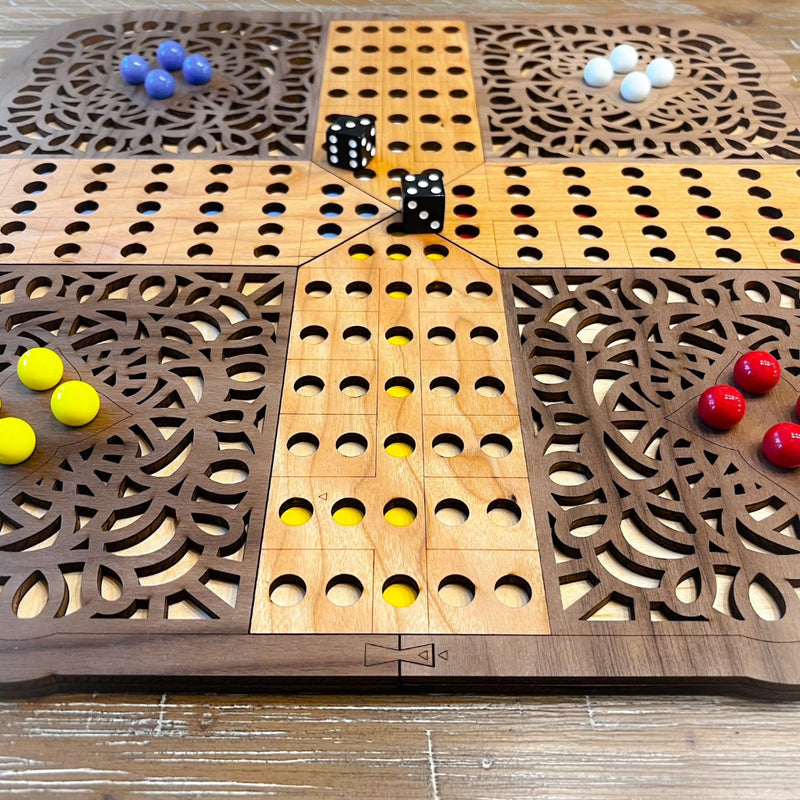 Wooden game board with various colored dice and marbles on a wooden surface