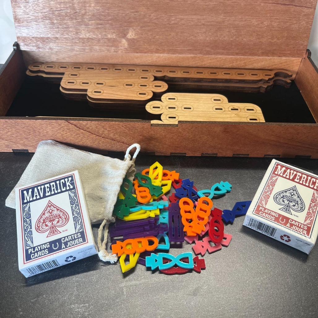 Colorful plastic pieces and Maverick playing cards on a wooden surface