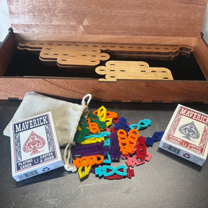 Colorful plastic pieces and Maverick playing cards on a wooden surface