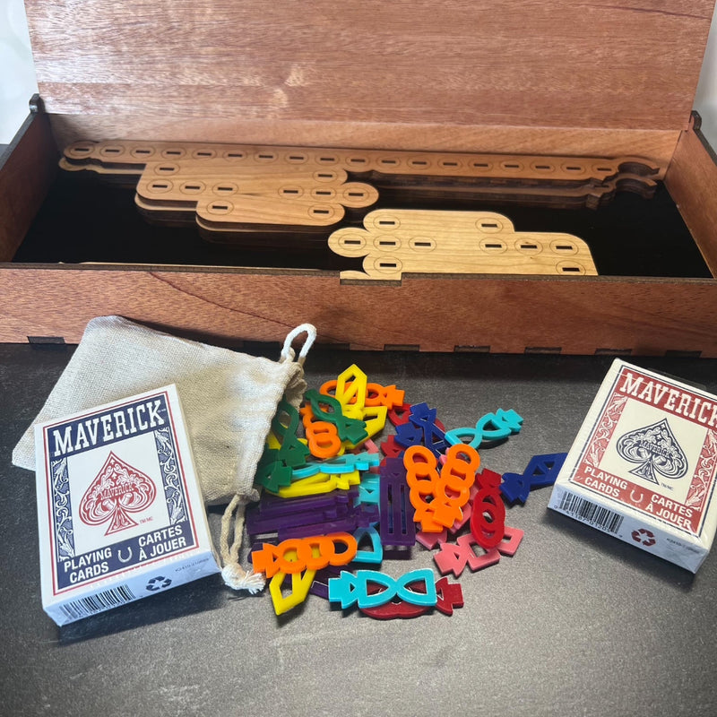 Colorful plastic pieces and Maverick playing cards on a wooden surface