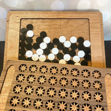 Load image into Gallery viewer, Wooden puzzle with circular and star-shaped pieces on a wooden board.