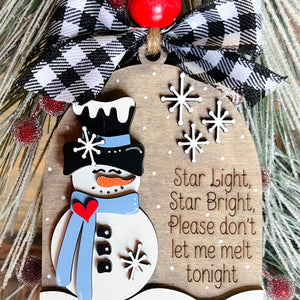 A decorative snowman ornament with a poem, black and white checkered bow, and red bead.