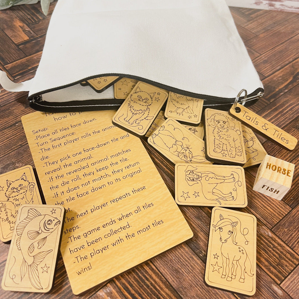 The image shows a memory matching game called Tails & Tiles, consisting of wooden tiles with animal illustrations, a wooden die, and an instruction card, all displayed on a wooden table.