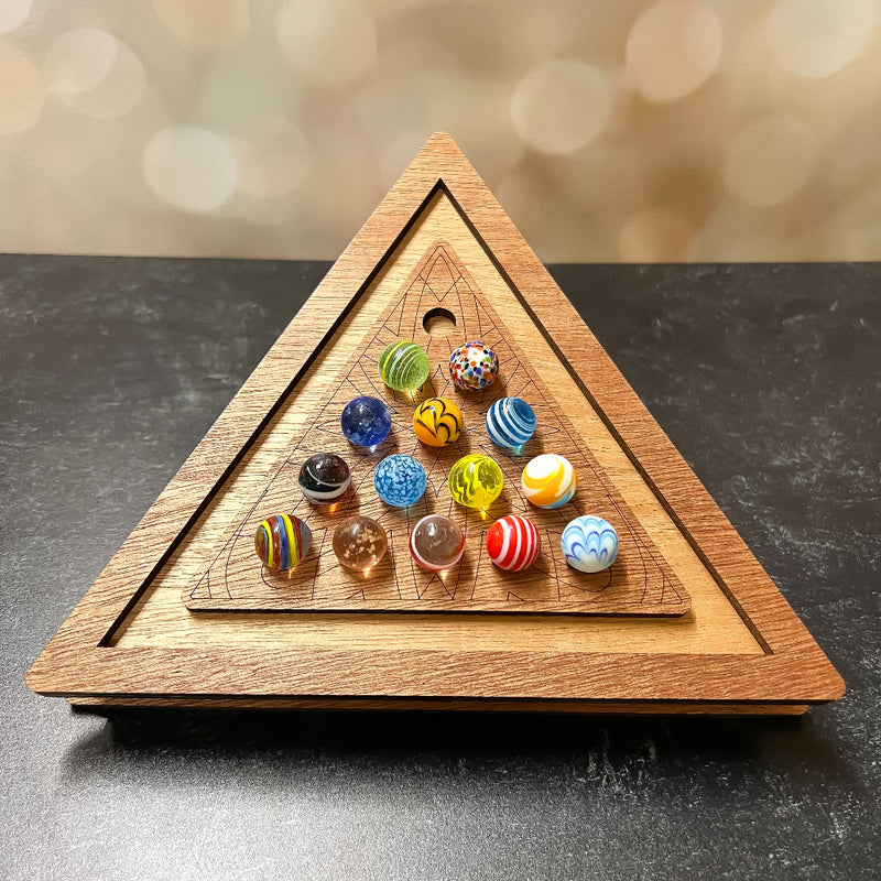 Triangle wooden marble solitaire game board filled with colorful marbles