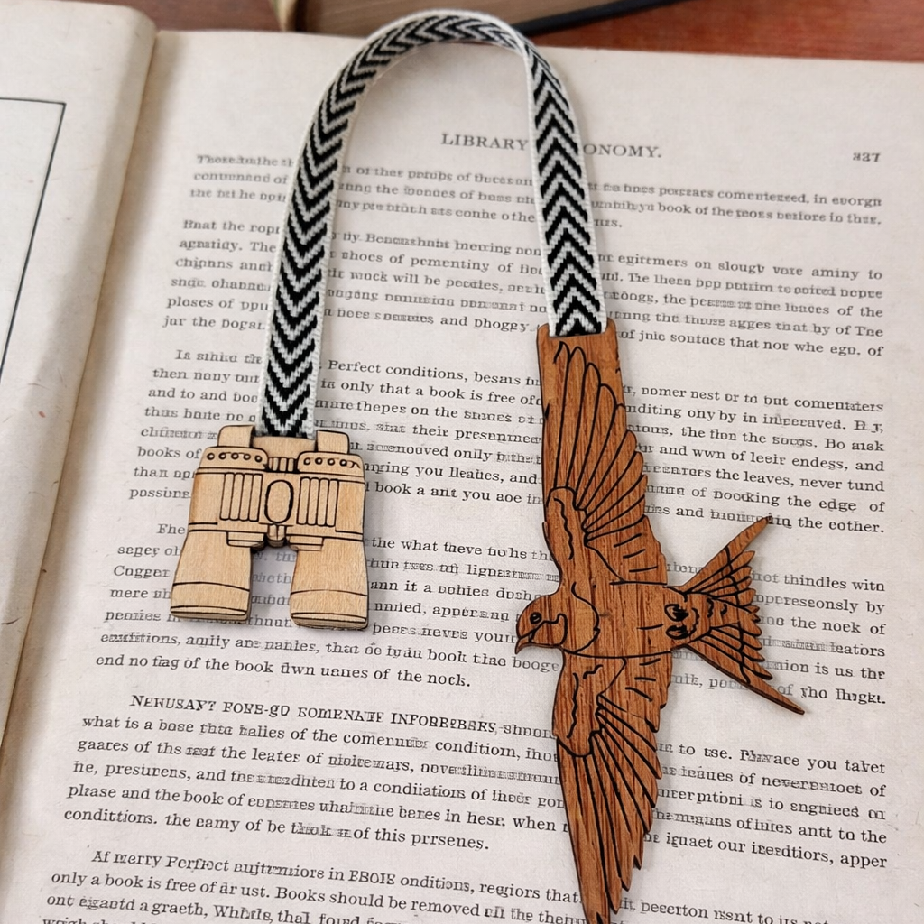 Wooden bookmark with bird and compass design on an open book