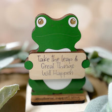 Load image into Gallery viewer, Green frog-shaped wooden figure with a motivational message on a blurred natural background