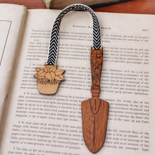 Load image into Gallery viewer, Wooden bookmark with trowel and plant design on an open book