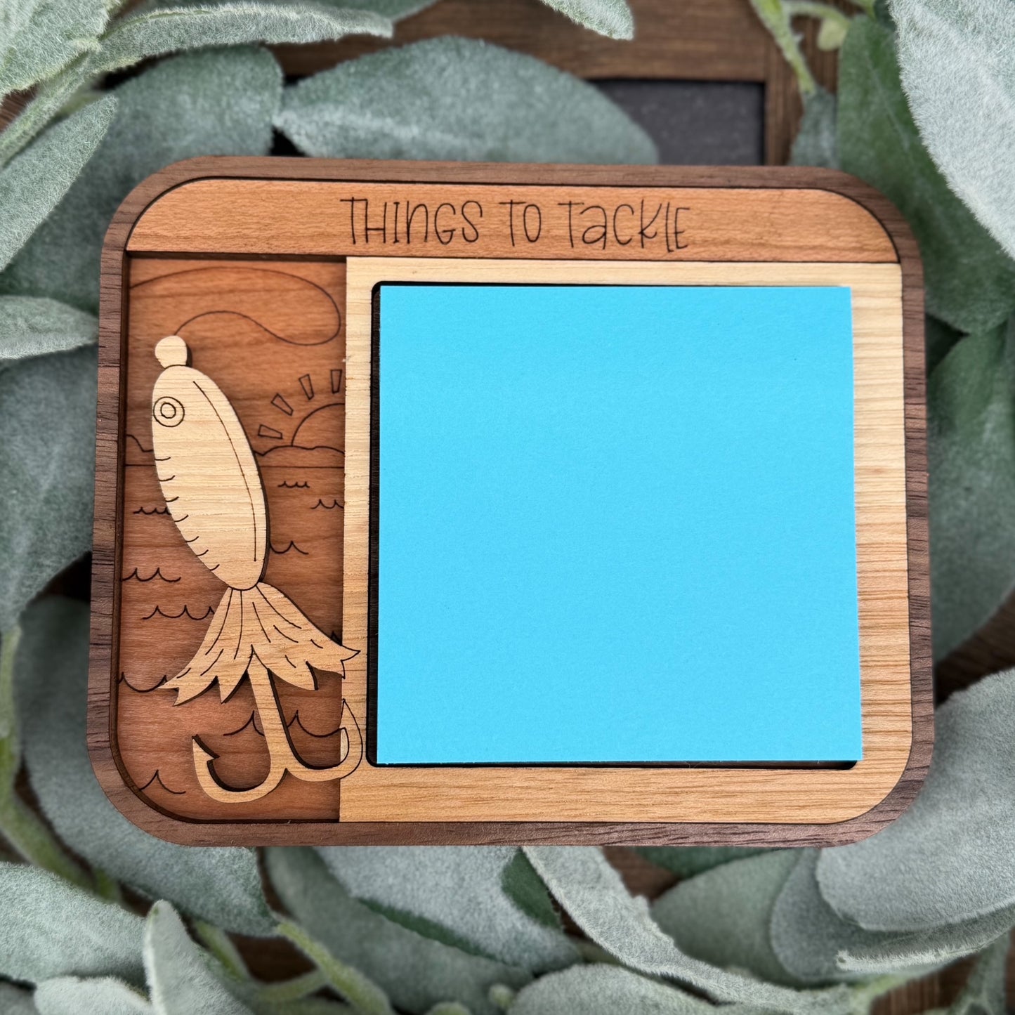 Wooden tray with fish design and 'Things to Tackle' text, surrounded by greenery.