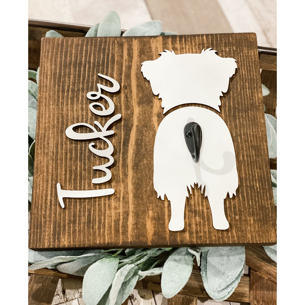 Wooden dog leash holder with white aussie silhouette, personalized name “Tucker,” and black metal hook on rustic wood background.